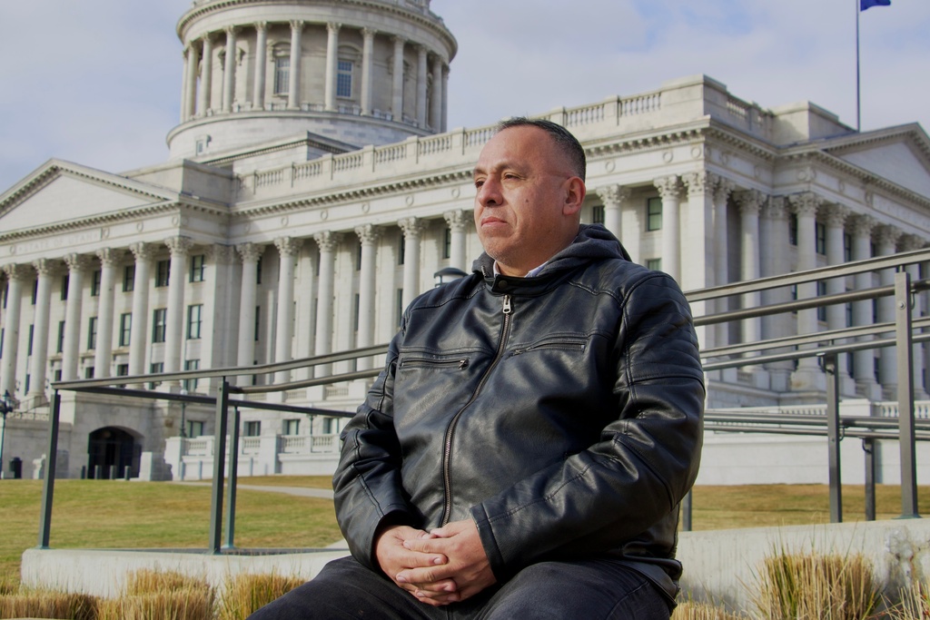 Manuel Coronel, a 54-year-old lawyer who left Venezuela in 2017 and eventually settled in Utah, sits for a portrait in front of the state's Capitol Building in Salt Lake City, Friday, Jan. 9, 2026. (AP Photo/Hannah Schoenbaum)