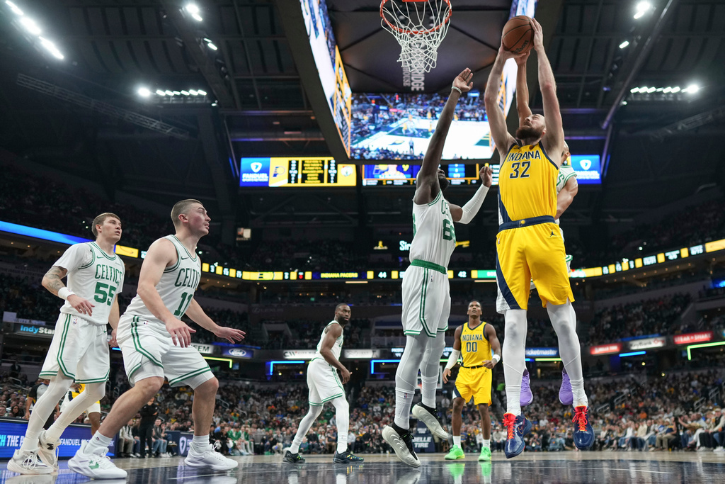 Indiana Pacers center Jay Huff, front right, goes up to shoot in front of Boston Celtics center Neemias Queta, second from front right, during the first half of an NBA basketball game in Indianapolis, Friday, Dec. 26, 2025. (AP Photo/AJ Mast)