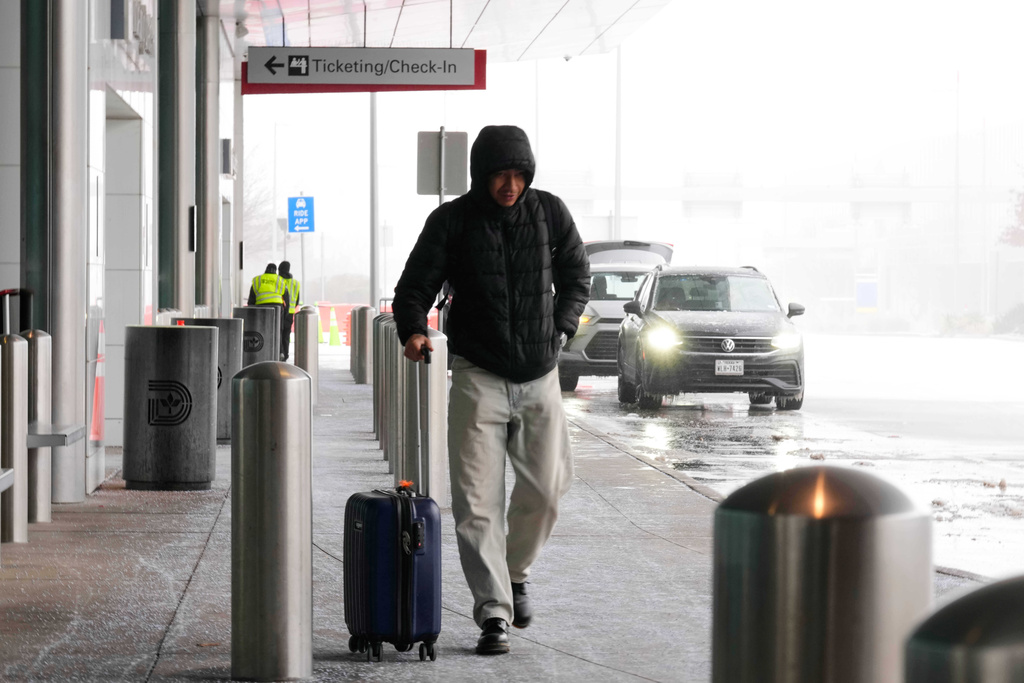 A man arrives at Love Field Airport for a scheduled flight to San Mateo, California that had not yet been cancelled Saturday, Jan. 24, 2026, in Dallas. (AP Photo/Tony Gutierrez)