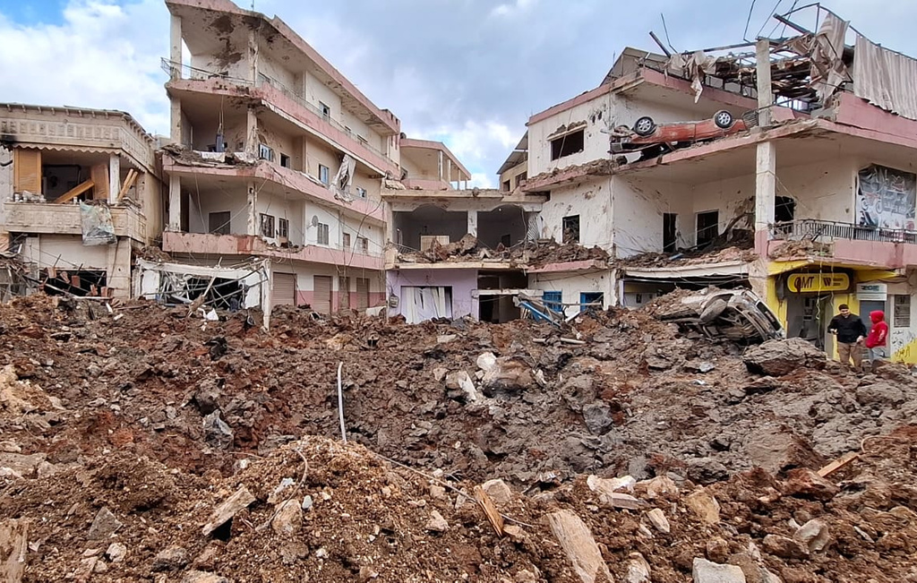 People check the damage left by Israeli airstrikes, Saturday, March 7, 2026, in the village of Nabi Chit, eastern Lebanon late Friday, where Israeli forces landed overnight and dug a grave in a cemetery searching for Israeli co-pilot Ron Arad who was captured and then went missing after his fighter jet crashed over south Lebanon in 1986. (AP Photo/Ali Salem)