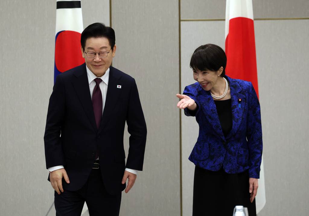South Kore's President Lee Jae Myung, left, is escorted by Japan's Prime Minister Sanae Takaichi at the start of their meeting in Nara, western Japan Tuesday, Jan. 13, 2026. (Issei Kato/Pool Photo via AP)