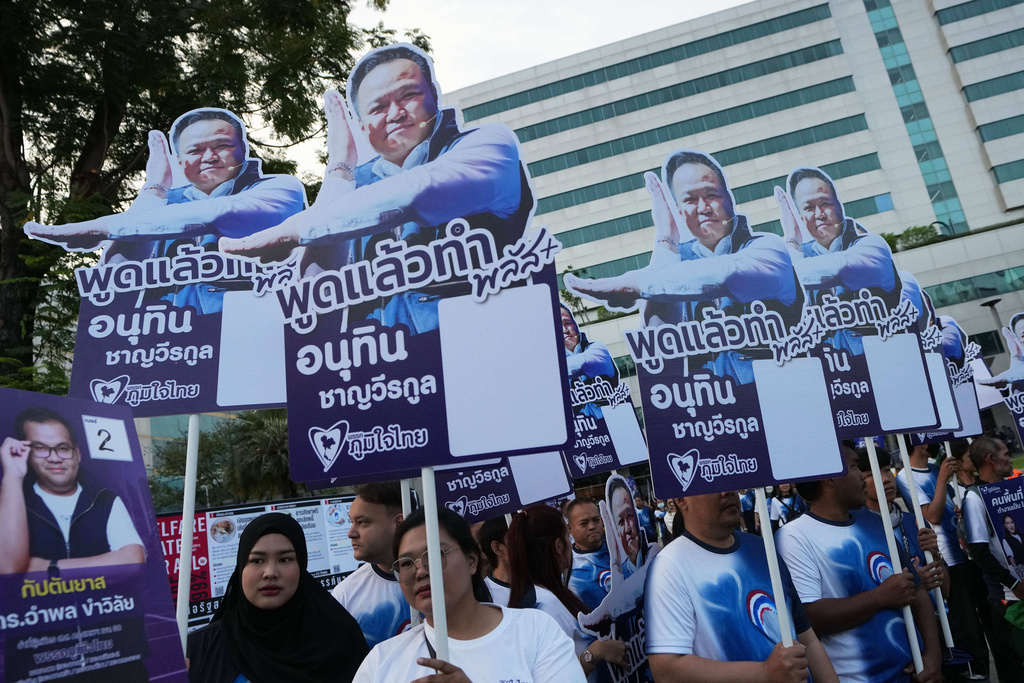 Supporters of Thailand's Prime Minister and leader of Bhumjaithai Party Anutin Charnvirakul, hold poster during a candidate registration in Bangkok, Thailand, Sunday, Dec. 28, 2025. (AP Photo/Sakchai Lalit)