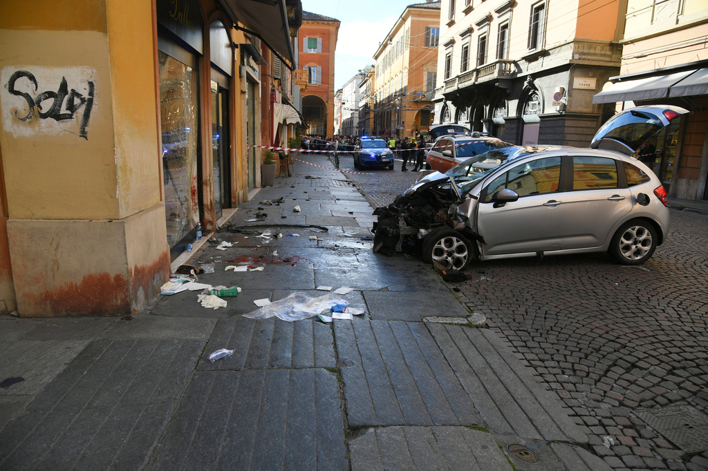 Blood is seen next to a destroyed car on a street of Modena, Italy, Saturday, May 16, 2026. (Lapresse via AP)
