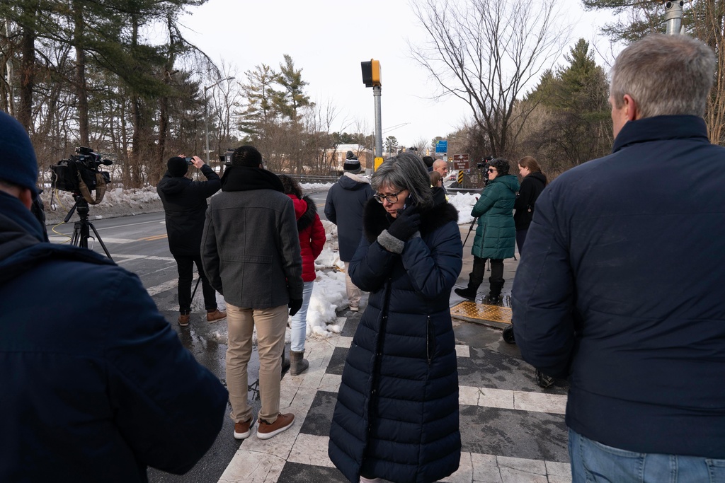 People wait outside Thomas S. Wootton High School for students in Rockville Md., Monday, Feb. 9, 2026, after a person was shot inside the school. (AP Photo/Jose Luis Magana)