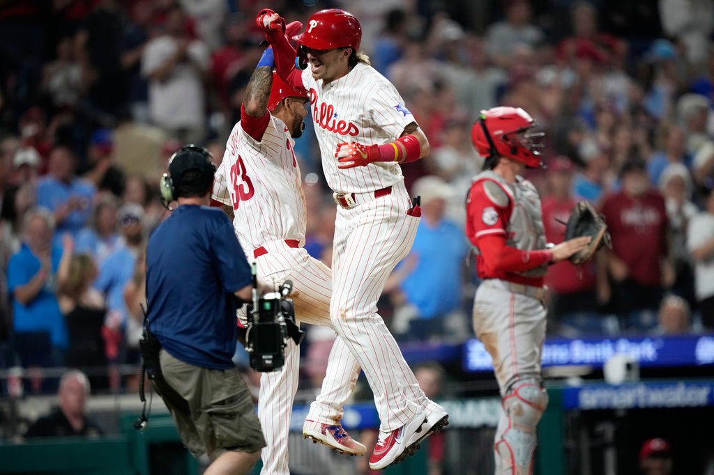 Philadelphia Phillies' Bryson Stott, center, celebrates with Edmundo Sosa, left, after hitting a two-run home run during the eighth inning of a baseball game against the Cincinnati Reds Monday, May 18, 2026, in Philadelphia. (AP Photo/Matt Slocum)