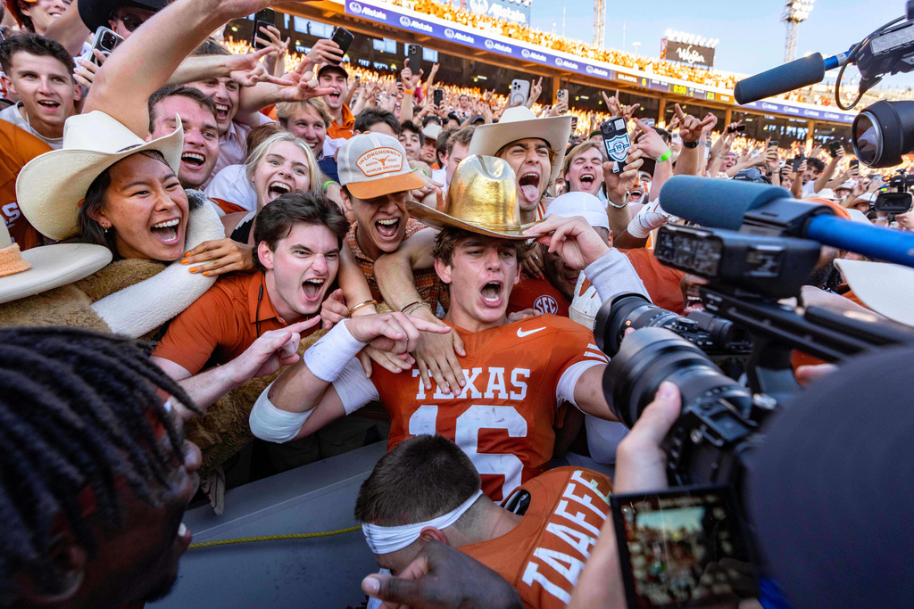 Texas quarterback Arch Manning, center, celebrates with fans after defeating Oklahoma in an NCAA college football game Saturday, Oct. 11, 2025, in Dallas. (AP Photo/Jeffrey McWhorter)