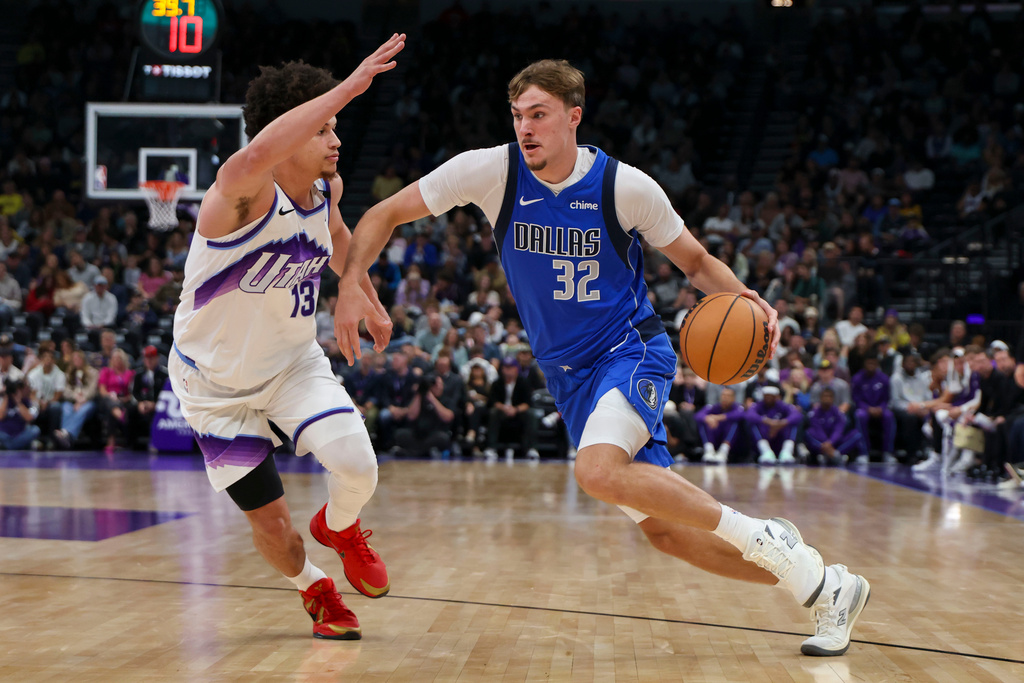 Dallas Mavericks forward Cooper Flagg (32) drives against Utah Jazz guard Walter Clayton Jr. (13) during the first half of a preseason NBA basketball game Monday, Oct. 13, 2025, in Salt Lake City. (AP Photo/Rob Gray)