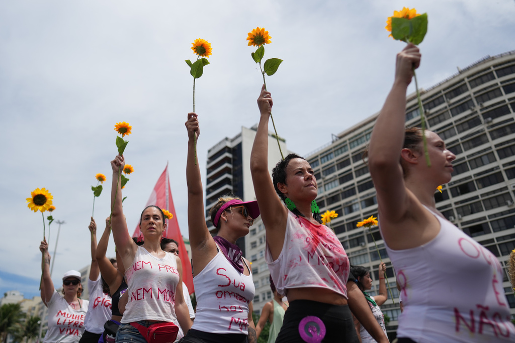 Women march marking International Women's Day on Copacabana beach, in Rio de Janeiro, Sunday, March 8, 2026. (AP Photo/Silvia Izquierdo)