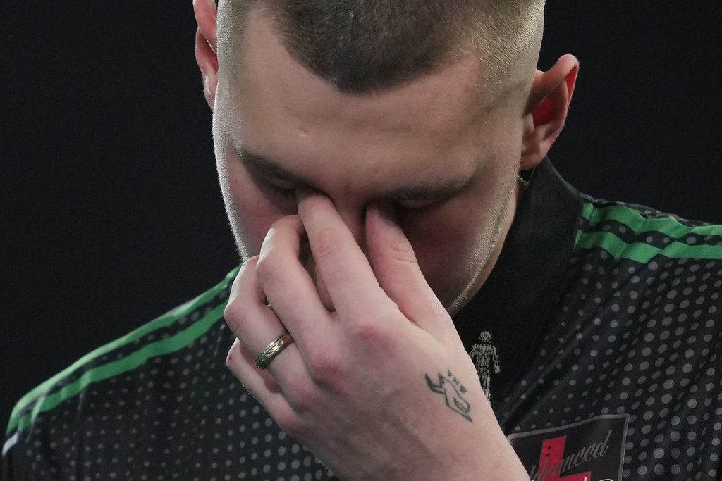 Tavis Dudeney of England reacts as he takes part in a round one match at the World Darts Championships, at Alexandra Palace in London, Monday, Dec. 15, 2025. (AP Photo/Kin Cheung)