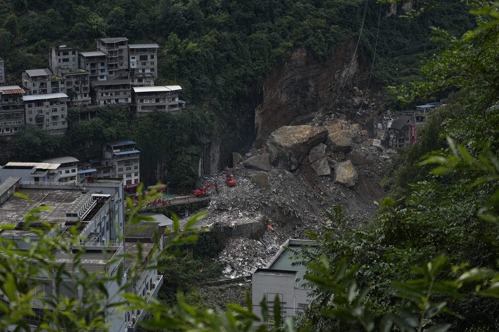 Rescuers use heavy machinery to clear rubble to search for trapped persons on the site of a landslide in Pengshui County, southwestern China's Chongqing on Sunday, July 19, 2026. (AP Photo/Andy Wong)