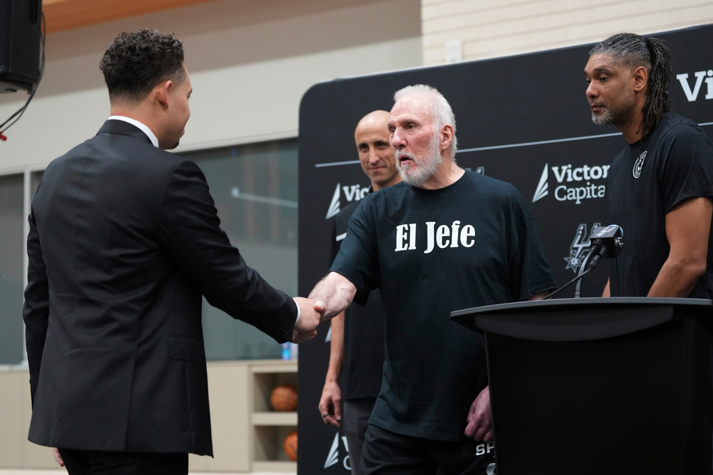 FILE - With the help of former players Manu Ginobili, back left, and Tim Duncan, right, former San Antonio Spurs head coach Gregg Popovich, center, introduces Mitch Johnson, left, as the new head coach of the San Antonio Spurs NBA basketball team, in San Antonio, May 5, 2025. (AP Photo/Eric Gay, File)