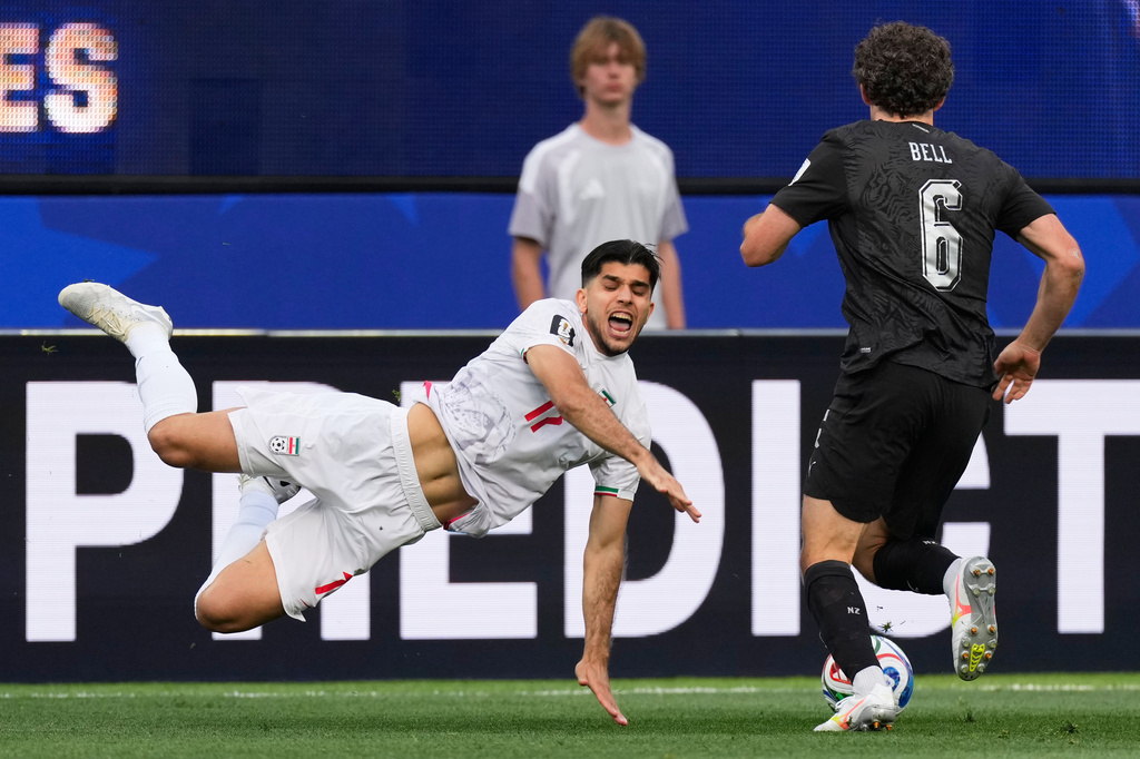 Iran's Arya Yousefi (17) and New Zealand's Joe Bell (6) battle for the ball during the World Cup Group G soccer match between Iran and New Zealand in Inglewood, Calif., near Los Angeles, Monday, June 15, 2026. (AP Photo/Mark J. Terrill)