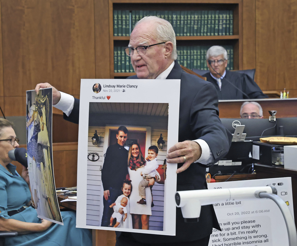 Defense attorney Kevin Reddington holds up a picture of th Clancy family before the murders during closing arguments in the Lindsay Clancy murder trial at Plymouth Superior Court in Plymouth, Mass., Thursday, Aug. 27, 2026. (Greg Derr/The Patriot Ledger via AP, Pool)
