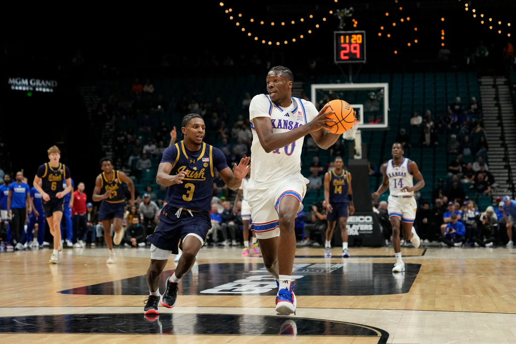 Kansas forward Flory Bidunga drives the ball against Notre Dame guard Markus Burton (3) during the first half of an NCAA college basketball game, Monday, Nov. 24, 2025, in Las Vegas. (AP Photo/Lucas Peltier)