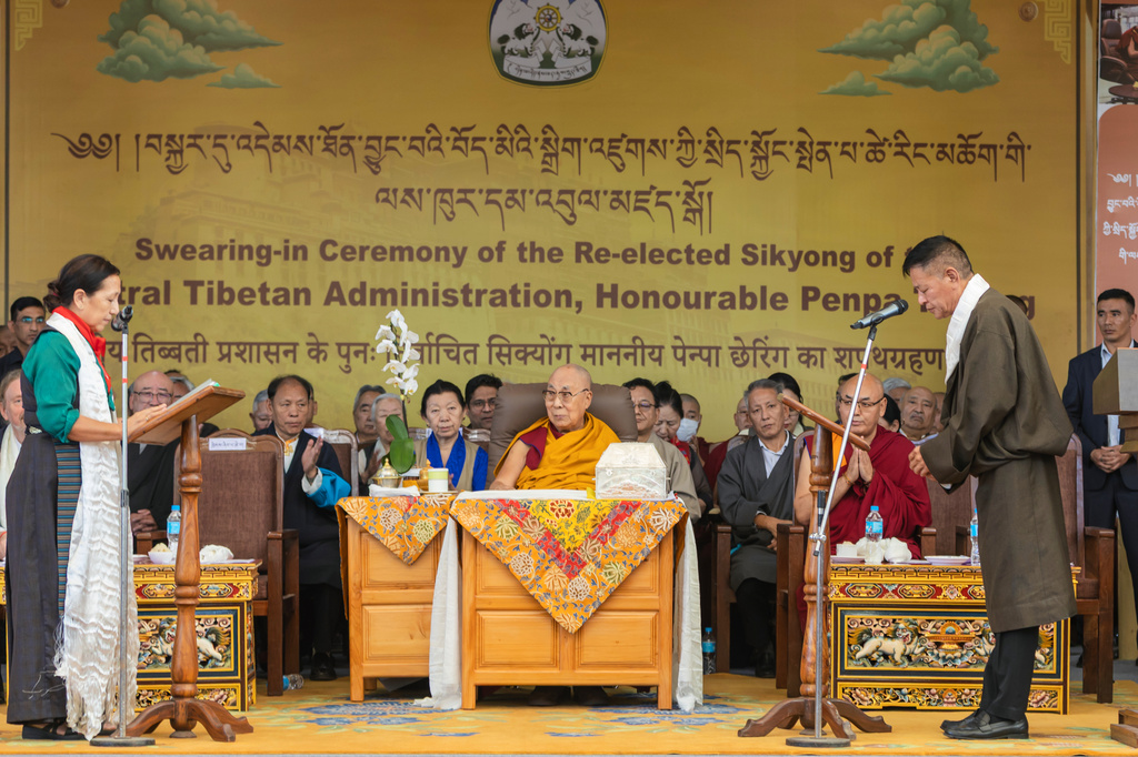 Chief Justice Commissioner of the Tibetan Supreme Justice Commission, Yeshi Wangmo, left, administers the oath of office to Penpa Tsering, right, as the political leader of Tibet's government-in-exile, in the presence of Tibetan spiritual leader the Dalai Lama, center, in Dharamshala, India, Wednesday, May 27, 2026. (AP Photo/ Shailesh Bhatnagar)