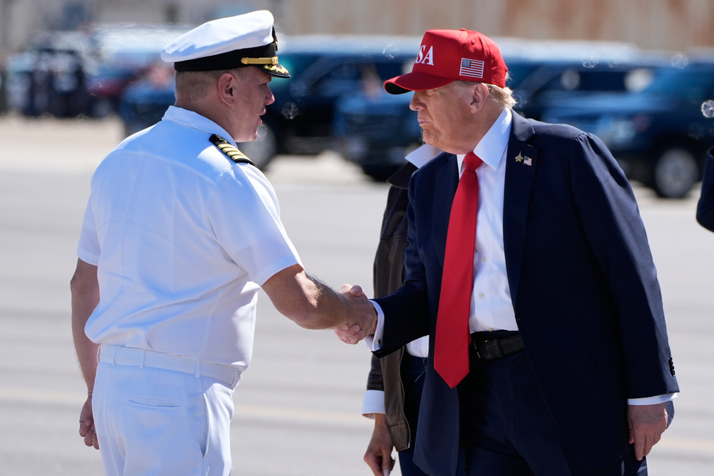 President Donald Trump greets Cape. Matt Schliemann, commanding officer of Naval Station Norfolk as he and first lady Melania Trump arrive on Air Force One at Naval Station Norfolk Chambers Field in Norfolk, Va., Sunday, Oct. 5, 2025. (AP Photo/Alex Brandon)