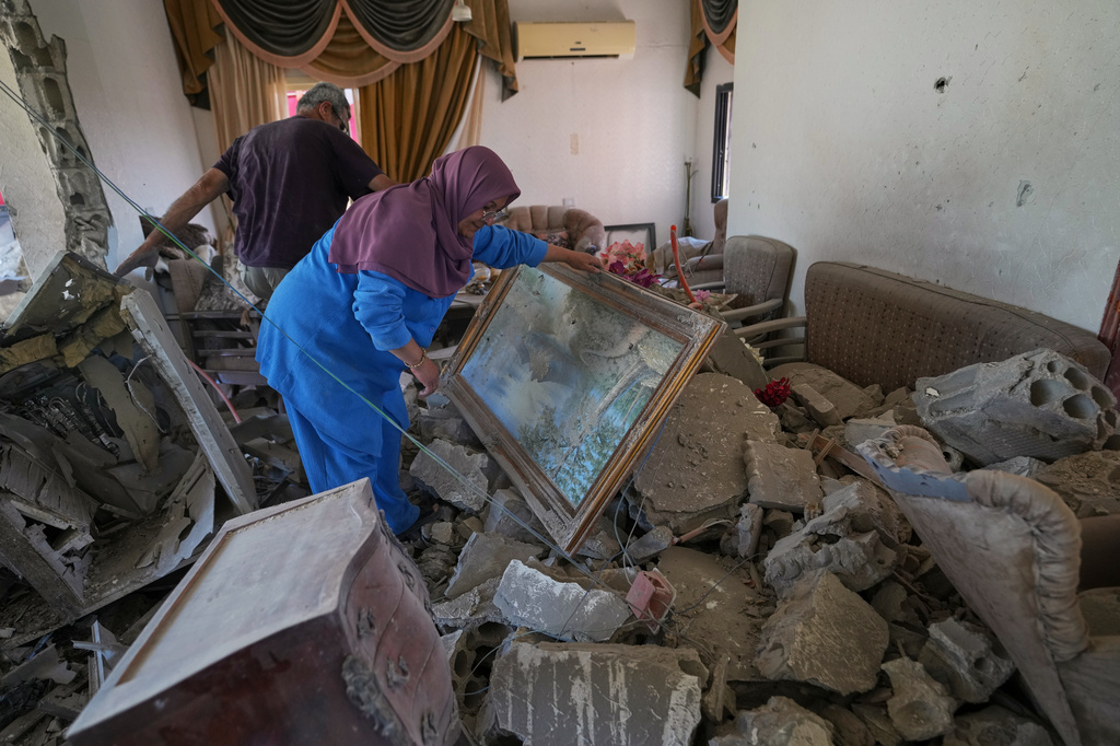 Mahasen Faqih and her husband, Mohammed Sobeih, inspect their home, destroyed during the Israeli military operation, after returning to it in Zawtar al-Gharbieh, Lebanon, Tuesday, July 28, 2026. (AP Photo/Hassan Ammar)