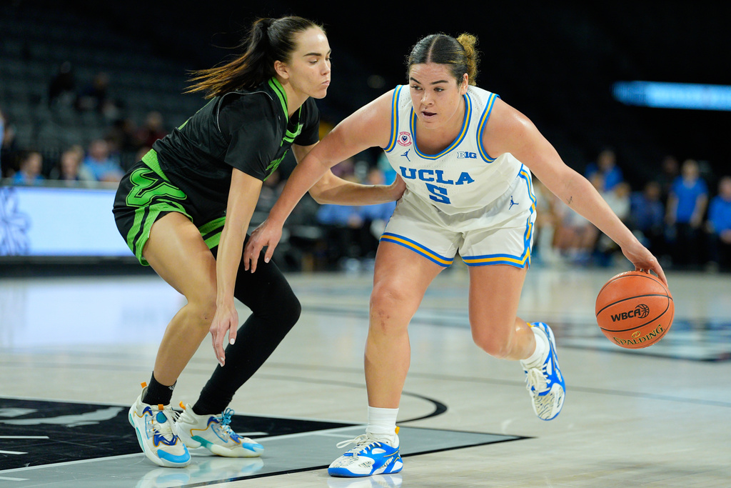 UCLA guard Charlisse Leger-Walker (5) drives against South Florida guard Janette Aarnio (9) during the first half of an NCAA college basketball game Saturday, Nov. 15, 2025, in Las Vegas. (AP Photo/John Locher)