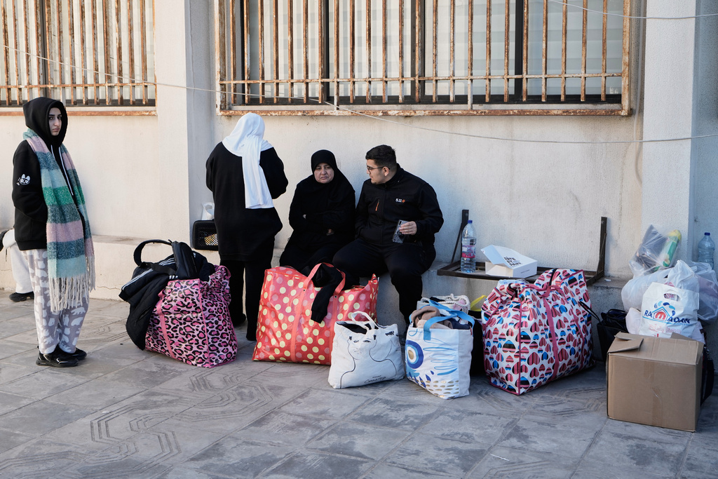 A displaced family who fled Israeli airstrikes in southern Lebanon sits at a school turned into a shelter, in Beirut, Lebanon, Monday, March 2, 2026. (AP Photo/Bilal Hussein)