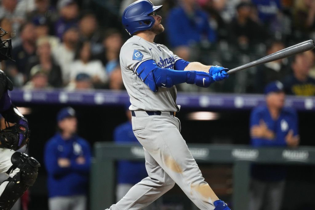 Los Angeles Dodgers' Max Muncy follows the flight of his solo home run of Colorado Rockies relief pitcher Tanner Gordon in the ninth inning of a baseball game Monday, April 20, 2026, in Denver. (AP Photo/David Zalubowski)