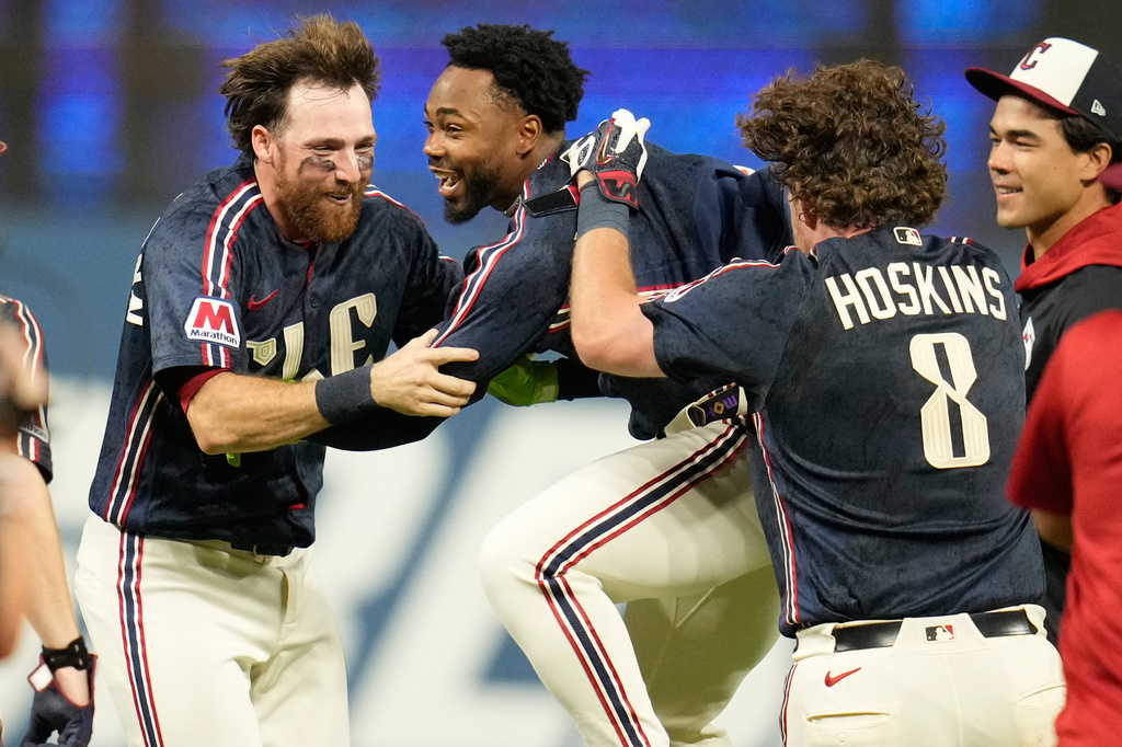 Cleveland Guardians' Kahlil Watson, center, celebrates with teammates Daniel Schneemann, left, and Rhys Hoskins (8) after hitting a game winning home run in the tenth inning of a baseball game against the Chicago White Sox in Cleveland, Friday, July 3, 2026. (AP Photo/Sue Ogrocki)