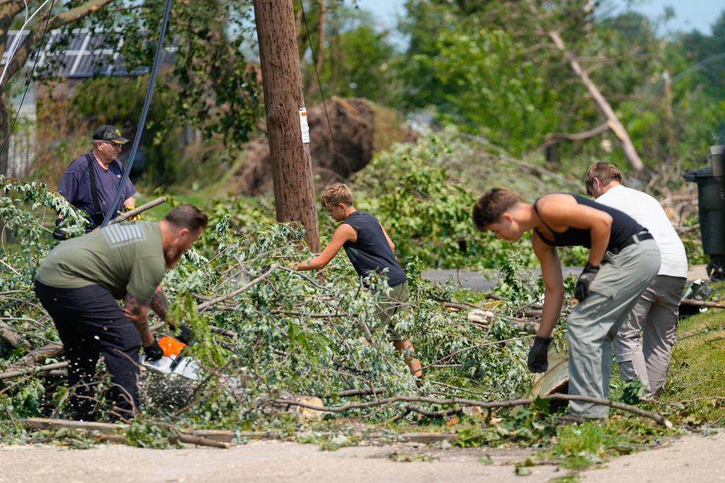 Volunteers help clear tree limbs near a damaged house after a tornado hit the day before in Appleton, Wis., Tuesday, July 28, 2026. (AP Photo/Kayla Wolf)