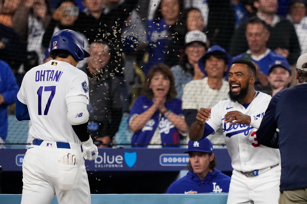 Los Angeles Dodgers' Shohei Ohtani, left, has seeds thrown at him by Teoscar Hernández after hitting a solo home run during the third inning of a baseball game against the San Francisco Giants, Tuesday, May 12, 2026, in Los Angeles. (AP Photo/Mark J. Terrill)