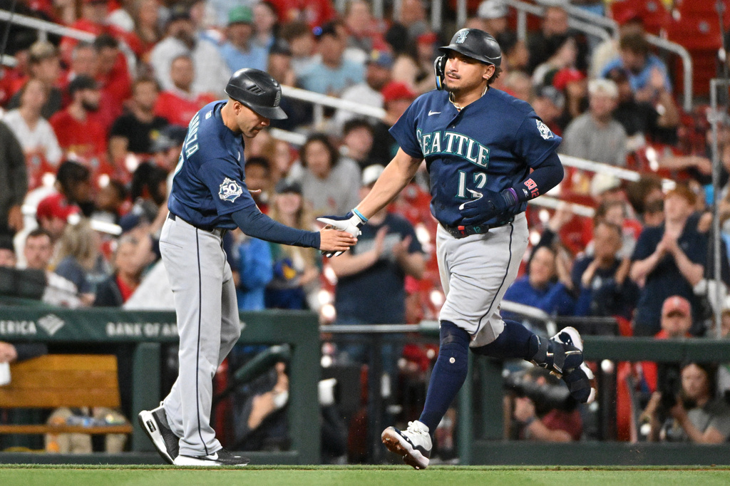 Seattle Mariners' Josh Naylor, right, is congratulated by third base coach Carlos Cardoza after hitting a home run against the St. Louis Cardinals during the sixth inning of a baseball game, Friday, April 24, 2026, in St. Louis. (AP Photo/Jeff Le)