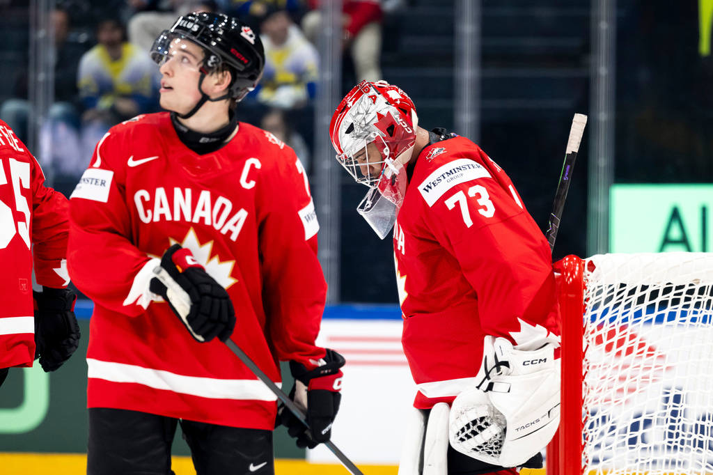 Canada's Macklin Celebrini, left, and goaltender Jet Greaves, right, react during a Group B preliminary round game between Canada and Sweden at the men's ice hockey world championship in Fribourg, Switzerland, Friday, May 15, 2026. (Anthony Anex/Keystone via AP)