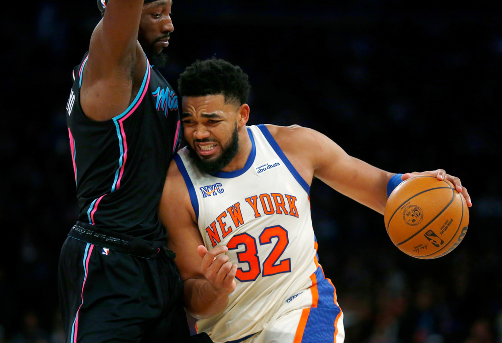 Miami Heat center Bam Adebayo, left, defends against New York Knicks center Karl-Anthony Towns, right, during the first half of an NBA basketball game Sunday, Dec. 21, 2025, in New York. (AP Photo/John Munson)