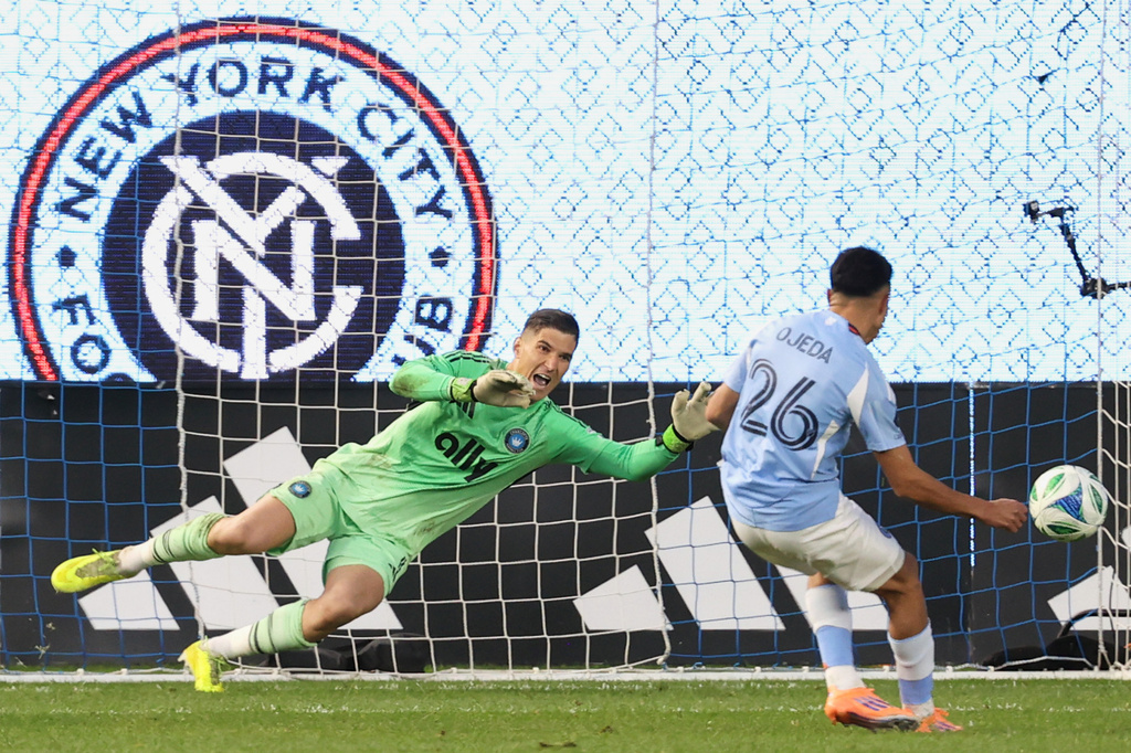 Charlotte FC goalkeeper Kristijan Kahlina (1) dives to save a shot by New York City forward Agustín Ojeda (26) during a shootout during Game 2 in the first round of MLS soccer's Eastern Conference playoffs Saturday, Nov. 1, 2025, in New York. (AP Photo/Pamela Smith)