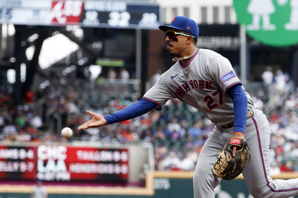 New York Mets first baseman Mark Vientos tosses back to first for the out on Atlanta Braves' Michael Harris II during the second inning of a baseball game, Sunday, Aug. 24, 2025, in Atlanta. (AP Photo/Butch Dill)