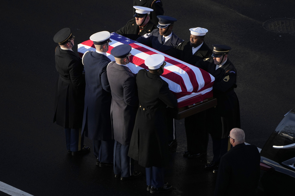 The flag-draped casket of former President Jimmy Carter is transferred to a horse-drawn caisson at the U.S. Navy Memorial before traveling on to the Capitol in Washington, Tuesday, Jan. 7, 2025, where Carter will lie in state. Carter died Dec. 29 at the age of 100. (AP Photo/Mark Schiefelbein, Pool)