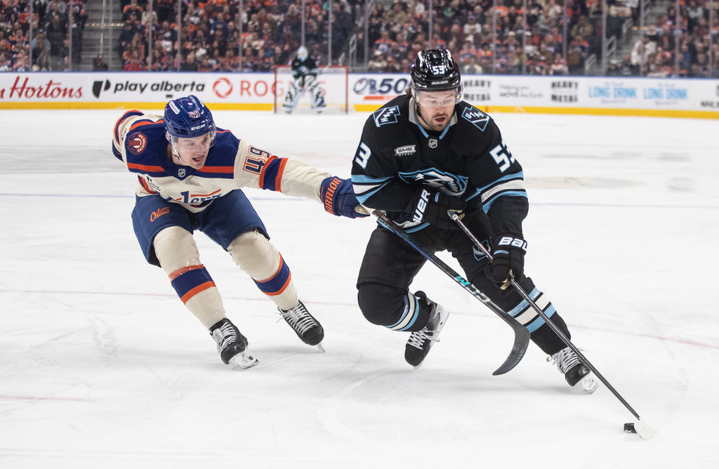 Utah Mammoth's Michael Carcone (53) and Edmonton Oilers' Ty Emberson (49) battle for the puck during the first period of an NHL hockey game in Edmonton, Alberta, on Tuesday, Oct. 28, 2025. (Jason Franson/The Canadian Press via AP)