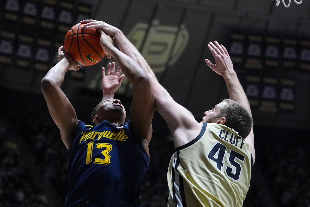 Purdue center Oscar Cluff (45) blocks the shot of Marquette forward Royce Parham (13) during the first half of an NCAA college basketball game in West Lafayette, Ind., Saturday, Dec. 13, 2025. (AP Photo/Michael Conroy)