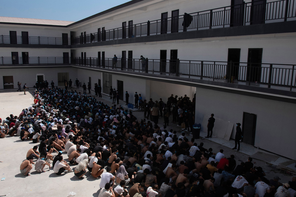 FILE - People from China, Vietnam and Ethiopia, believed to have been trafficked and forced to work in scam centers, sit with their faces masked while in detention after being released from the centers in Myawaddy district in eastern Myanmar, Feb. 26, 2025. (AP Photo/Thanaphon Wuttison, File)
