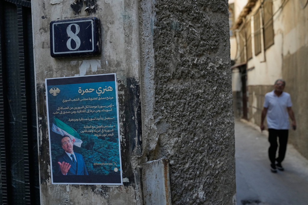 A poster shows Syrian-American Jew Henry Hamra, a candidate for the Syrian Parliamentary elections, in the Jewish neighborhood of old Damascus, Syria Friday, Oct. 3, 2025. (AP Photo/Hussein Malla)