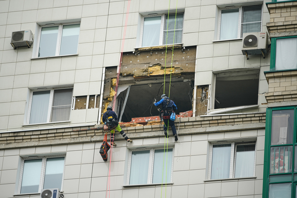 Municipal employees work at the side of a damaged multi-storey apartment building hit by a Ukrainian drone in Krasnogorsk, just outside Moscow, Russia, on Friday, Oct. 24, 2025. (AP Photo/Pavel Bednyakov)