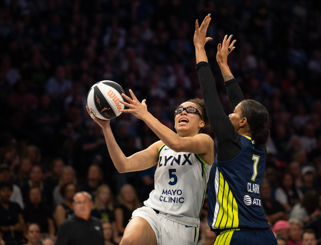 Minnesota Lynx guard Olivia Miles (5) puts up a shot in front of Dallas Wings forward Alysha Clark (7) in the first half of a WNBA basketball game Tuesday, June 9 2026, in Minneapolis. (Jeff Wheeler/Minnesota Star Tribune via AP)