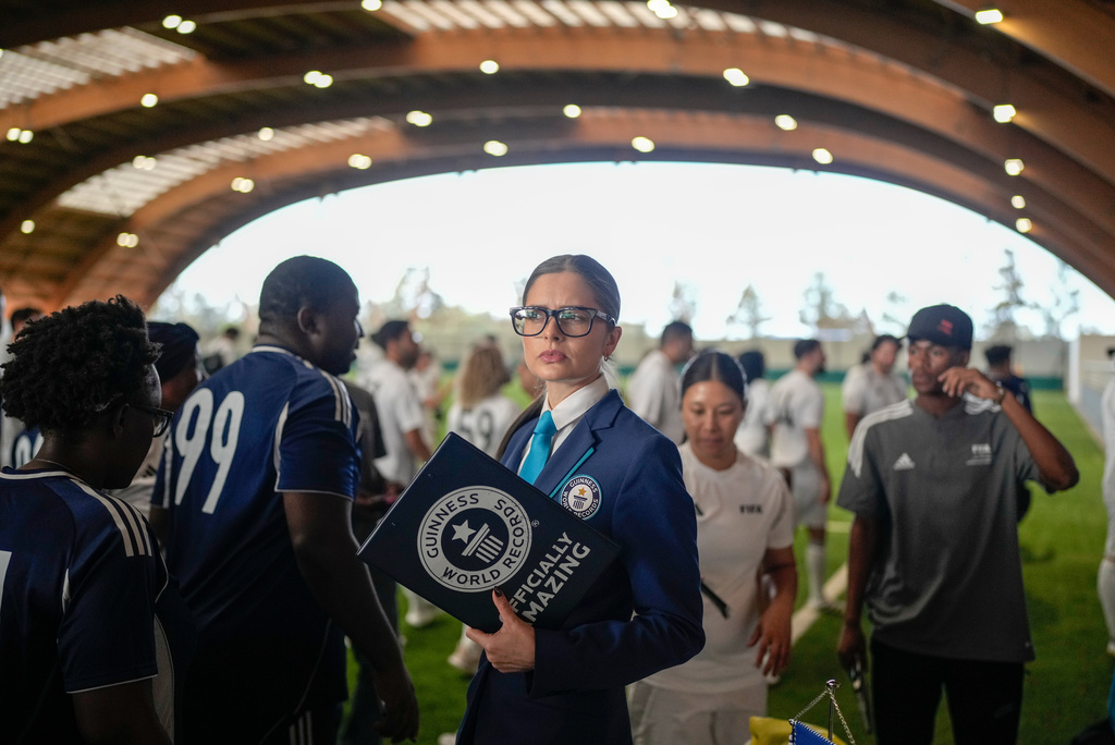 Joanne Brent, front center, Guiness World Records adjudicator, prepares to monitor an exhibition soccer match organised by FIFA attempting to break the Guinness World Record for most nationalities in a match, in Rabat, Morocco, Wednesday, Nov. 5, 2025. (AP Photo/Mosa'ab Elshamy)