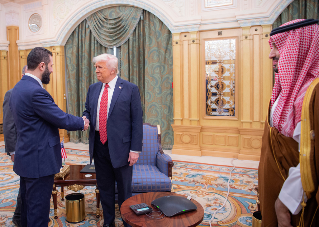 FILE - In this photo provided by the Saudi Royal Palace, Syria's interim President Ahmad al-Sharaa, left, shakes hands with U.S. President Donald Trump in Riyadh, Saudi Arabia, Wednesday, May 14, 2025. At foreground right is Saudi Crown Prince Mohammed bin Salman. (Bandar Aljaloud/Saudi Royal Palace via AP, File)