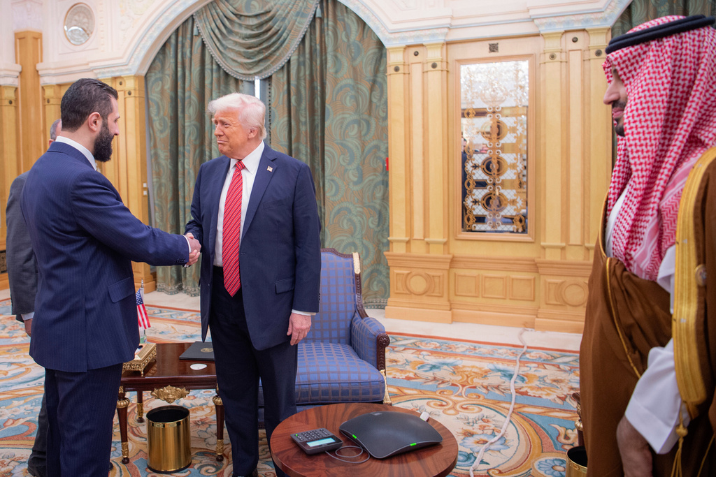 FILE - In this photo provided by the Saudi Royal Palace, Syria's interim President Ahmad al-Sharaa, left, shakes hands with U.S. President Donald Trump in Riyadh, Saudi Arabia, Wednesday, May 14, 2025. At foreground right is Saudi Crown Prince Mohammed bin Salman. (Bandar Aljaloud/Saudi Royal Palace via AP, File)