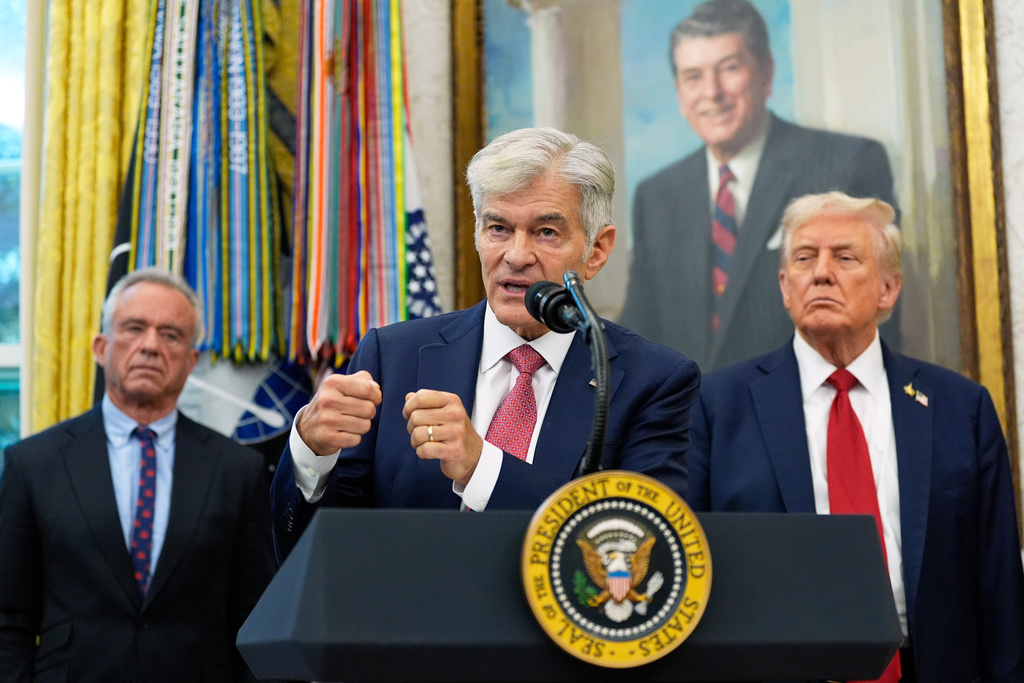 Mehmet Oz, Administrator for the Centers for Medicare & Medicaid Services, speaks in the Oval Office of the White House, Tuesday, Sept. 30, 2025, in Washington, as President Donald Trump, right, and Secretary of Health and Human Services Robert F. Kennedy, Jr., look on. (AP Photo/Alex Brandon)