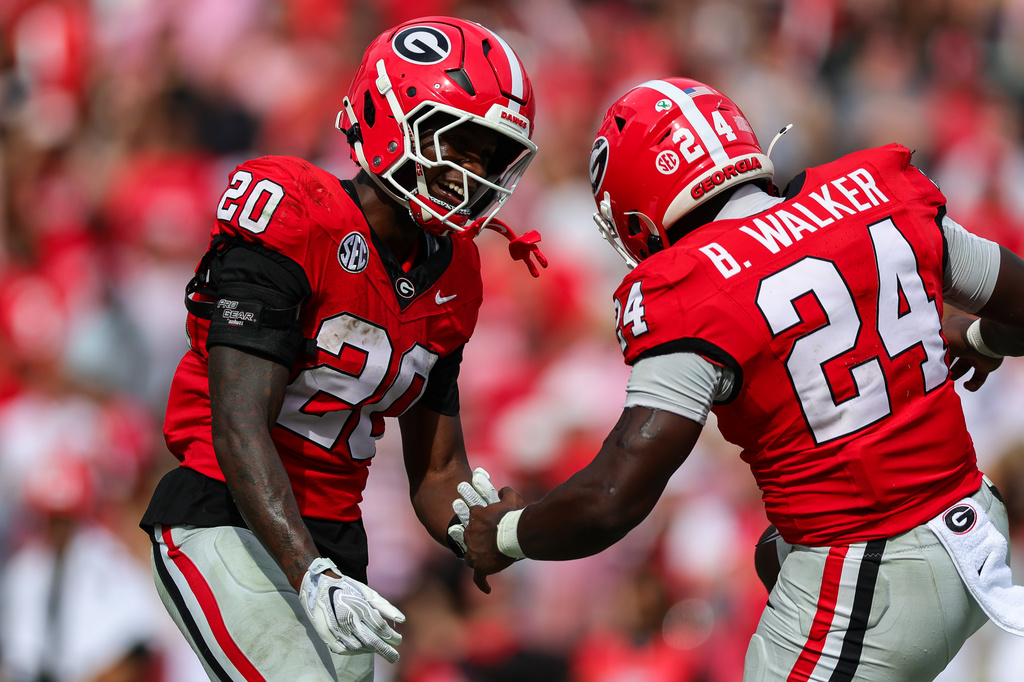Georgia running back Dwight Phillips Jr. (20) high-fives running back Bo Walker (24) after scoring a touchdown during the second half of an NCAA college football game against Vanderbilt, Saturday, Oct. 3, 2026, in Athens, Ga. (AP Photo/Colin Hubbard)