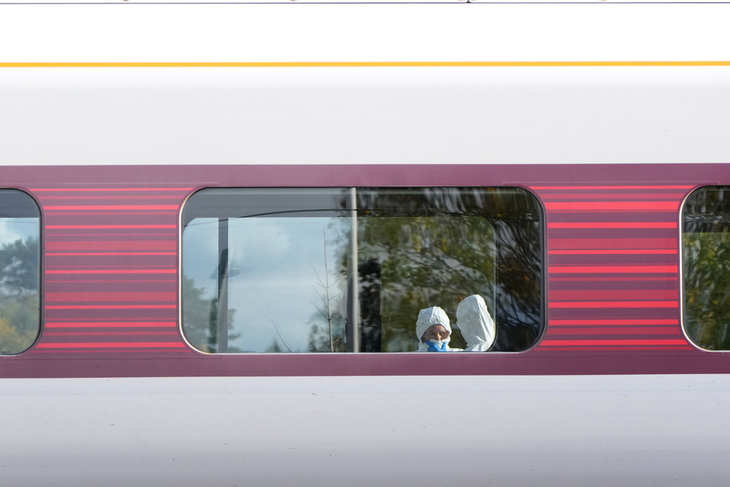 Forensic investigators are seen at the train after a mass stabbing on a London-bound train in Huntingdon, England, Sunday, Nov. 2, 2025.(AP Photo/Kirsty Wigglesworth)