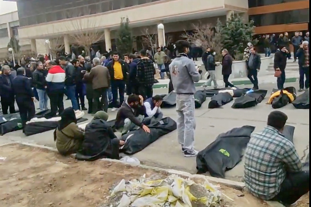 FILE - This image from video taken between Jan. 9 and Jan. 11, 2026, and verified by AP, shows mourners next to the bodies of people who were brought from different locations, outside a morgue in Kahrizak, in Iran's Tehran province, after a crackdown on protests. (UGC via AP, File)