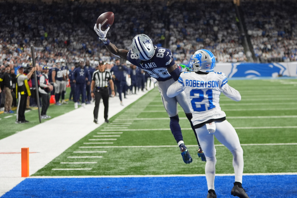 Dallas Cowboys wide receiver Ceedee Lamb (88) attempts a catch in front of Detroit Lions cornerback Amik Robertson (21) during the second half of an NFL football game Thursday, Dec. 4, 2025, in Detroit. (AP Photo/Paul Sancya)