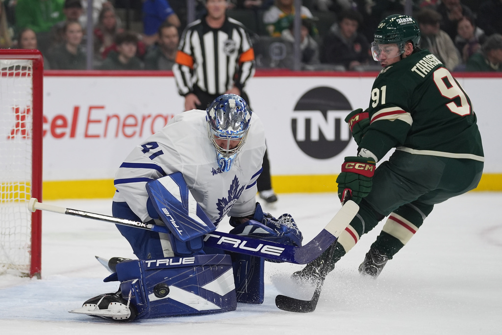 Toronto Maple Leafs goaltender Dennis Hildeby (41) blocks a shot while pressured by Minnesota Wild right wing Vladimir Tarasenko (91) during the first period of an NHL hockey game, Sunday, March 15, 2026, in St. Paul, Minn. (AP Photo/Abbie Parr)