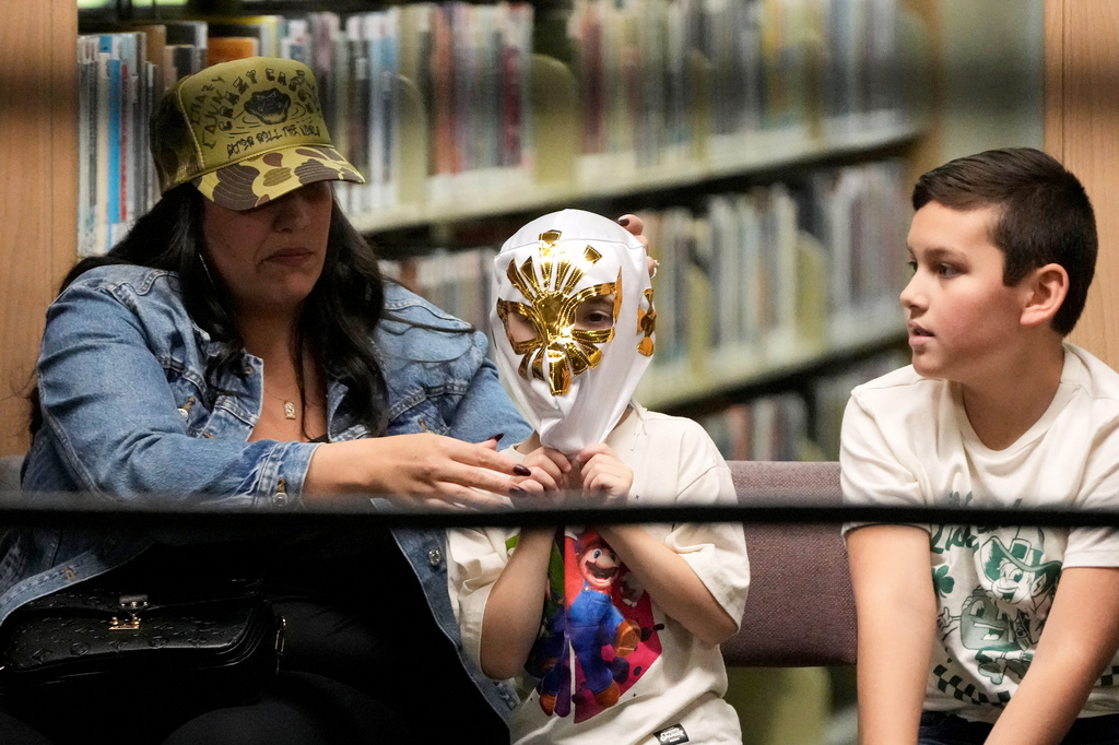 A fan has his mask adjusted during a Lucha Libro pro wrestling event at Benicia Public Library Saturday, May 2, 2026, in Benicia, Calif. (AP Photo/Jeff Chiu)