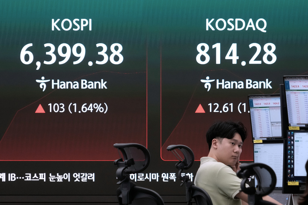 A currency trader watches monitors near a screen showing the Korea Composite Stock Price Index (KOSPI) at the foreign exchange dealing room of the Hana Bank headquarters in Seoul, South Korea, Friday, Aug. 7, 2026. (AP Photo/Ahn Young-joon)